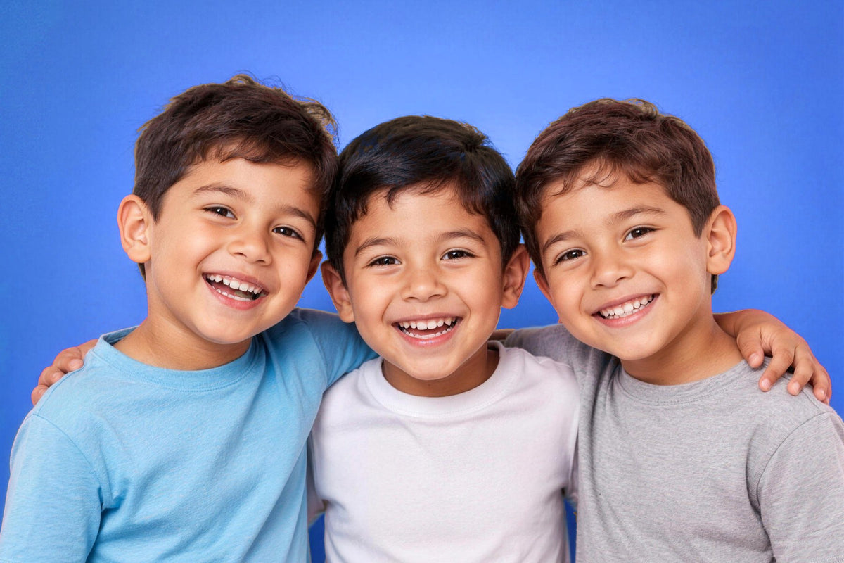 Tres niños sonrientes abrazados, calzado para niños FVN